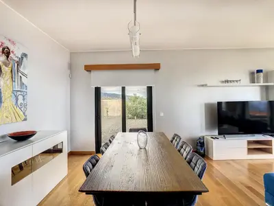 a living room with a wooden table and a tv at Rising Sun Villa in Gaula