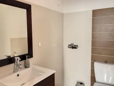a bathroom with a sink and a mirror and a toilet at Rising Sun Villa in Gaula