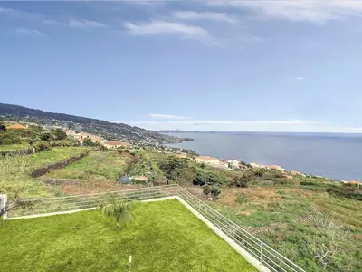an aerial view of a grassy hill next to the ocean at Rising Sun Villa in Gaula