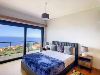a bedroom with a bed and a large window at Rising Sun Villa in Gaula