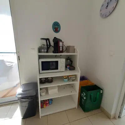 a small white shelf with a microwave on it at Oceanview Getaway in Caniço