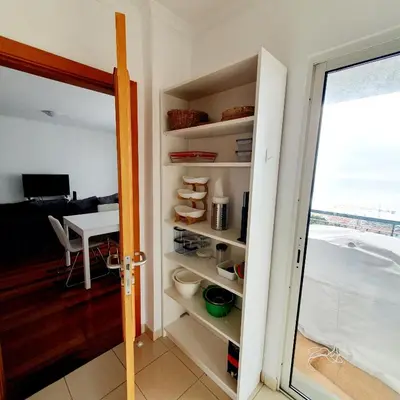 a room with a door open to a room with a table at Oceanview Getaway in Caniço