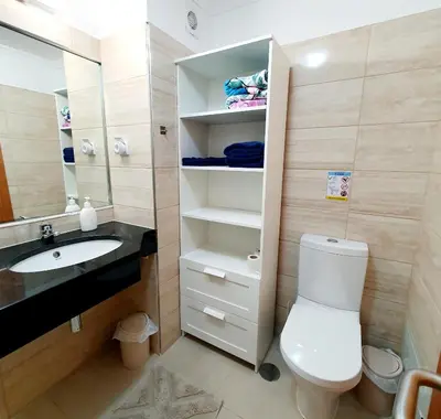 a bathroom with a toilet and a sink and a mirror at Oceanview Getaway in Caniço