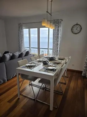 a white dining room table with chairs in a living room at Oceanview Getaway in Caniço