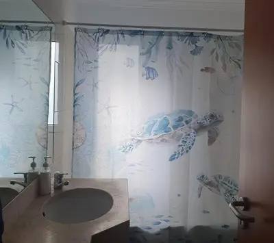 a bathroom with a turtle shower curtain and a sink at Oceanview Getaway in Caniço