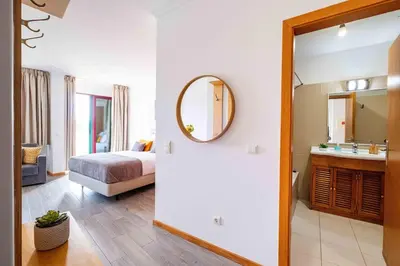 a hotel room with a bed and a mirror at Enjoy Madeira 1 in Caniço
