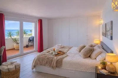 a bedroom with a bed with a view of the ocean at Bliss Luz Horizon - Panoramic Sea View - 50m to Beach - Central Praia da Luz - Walk distance to Everywhere in Luz