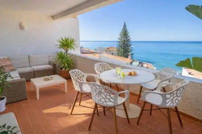 a patio with a table and chairs and the ocean at Bliss Luz Horizon - Panoramic Sea View - 50m to Beach - Central Praia da Luz - Walk distance to Everywhere in Luz