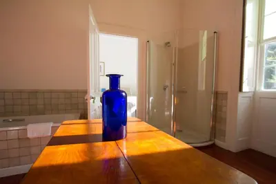 a blue bottle sitting on a wooden table in a bathroom at Quinta das Malvas - Quinta de Santa Luzia in Funchal