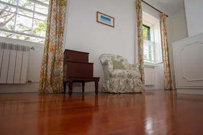 a living room with a chair and a piano at Quinta das Malvas - Quinta de Santa Luzia in Funchal