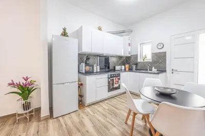 a kitchen with a table and a white refrigerator at Ferreira's Retreat in Ponta do Sol