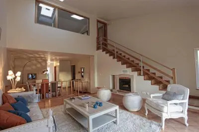 a living room with a couch and a staircase at Villas T3 com Jardim Vila Sagres in Sagres