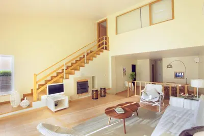 a large living room with a staircase and a living room at Villas T3 com Jardim Vila Sagres in Sagres