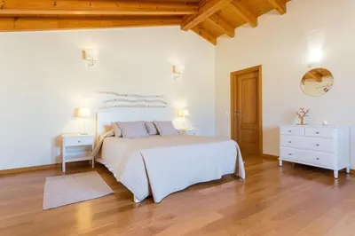 a bedroom with a white bed and a wooden floor at Villas T3 com Jardim Vila Sagres in Sagres