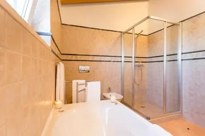 a bathroom with a large tub and a shower at Villas T3 com Jardim Vila Sagres in Sagres