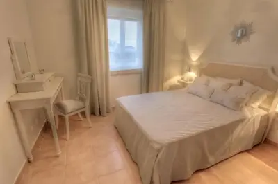 a bedroom with a bed and a desk and a window at Villas T3 com Jardim Vila Sagres in Sagres
