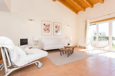 a living room with a white couch and a table at Villas T3 com Jardim Vila Sagres in Sagres