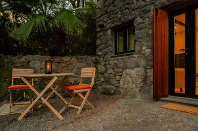 a table and two chairs sitting next to a building at Casas da Terça - modern comfort in traditional houses set within 300sqm of private gardens to explore in Tábua