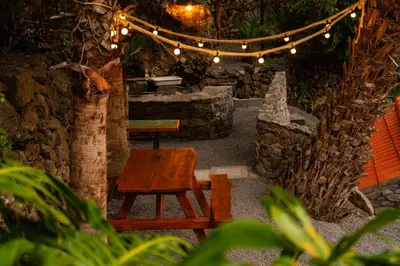 a room with a table and a chair and lights at Casas da Terça - modern comfort in traditional houses set within 300sqm of private gardens to explore in Tábua