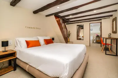 a bedroom with a large white bed with orange pillows at Casas da Terça - modern comfort in traditional houses set within 300sqm of private gardens to explore in Tábua