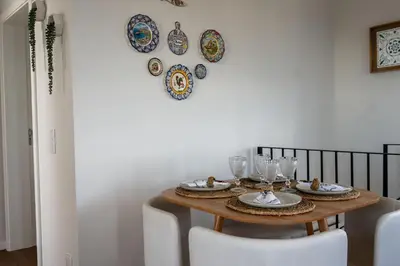 a dining room table with plates and glasses on the wall at Ozeanica Heights by LovelyStay in Gaula