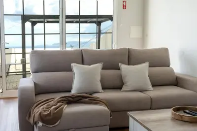 a living room with a couch with pillows at Ozeanica Heights by LovelyStay in Gaula