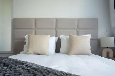 a white bed with white pillows and a headboard at Ozeanica Heights by LovelyStay in Gaula