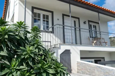 a white house with stairs and plants in front of it at Ozeanica Heights by LovelyStay in Gaula