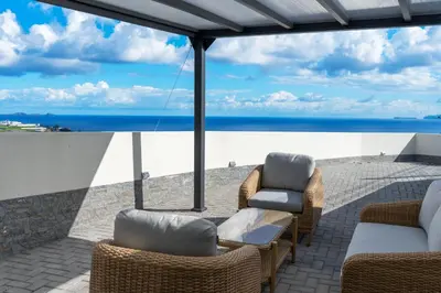 a patio with a view of the ocean at Ozeanica Heights by LovelyStay in Gaula