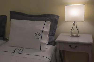 a bed with a pillow and a table with a lamp at Apartments Madeira Santa Maria in Funchal