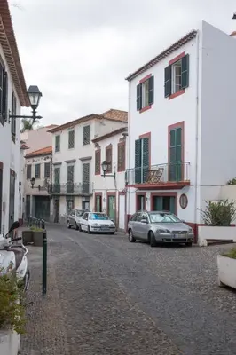 a group of cars parked on a street with buildings at Apartments Madeira Santa Maria in Funchal