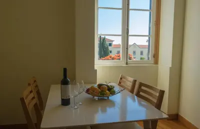 a table with a bowl of fruit and a bottle of wine at Apartments Madeira Santa Maria in Funchal