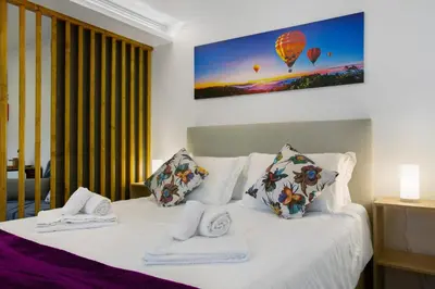 a bedroom with a bed with two pillows and a hot air balloon at Litlle Zen House in Santana