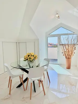 a dining room with a glass table and white chairs at Refúgio do Vale Verde in Ponta do Sol