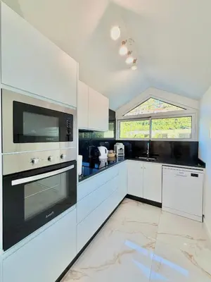 a kitchen with white cabinets and a stove top oven at Refúgio do Vale Verde in Ponta do Sol