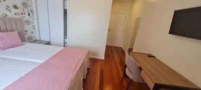 a bedroom with a bed and a flat screen tv at Casa Linda Baía in Porto da Cruz