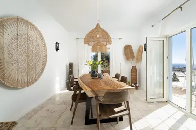 a dining room with a table and a view of the ocean at Cliffside Boho Villa in Luz