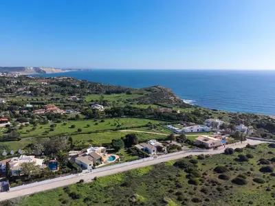 an aerial view of a house and the ocean at Cliffside Boho Villa in Luz