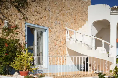 a building with a staircase and a window at Cliffside Boho Villa in Luz