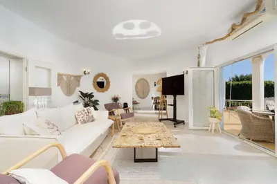 a living room with a white couch and a tv at Cliffside Boho Villa in Luz