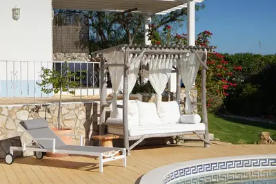 a gazebo with white chairs on a patio at Cliffside Boho Villa in Luz
