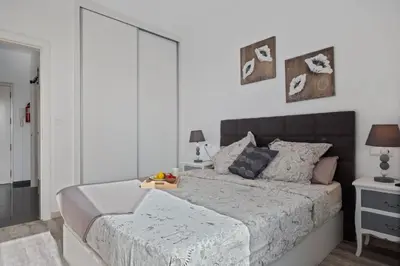 a bedroom with a large bed with white walls at Apartamento Costa in Funchal