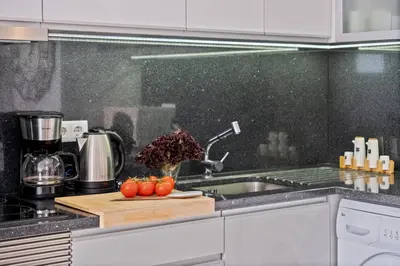 a kitchen with a sink and tomatoes on a cutting board at Apartamento Costa in Funchal