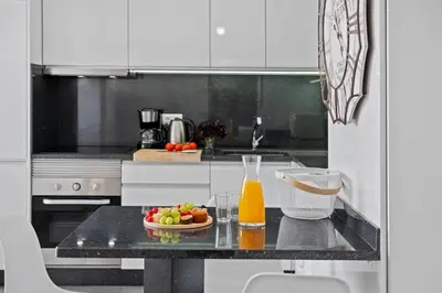 a kitchen with a table with a bowl of fruit and a drink at Apartamento Costa in Funchal