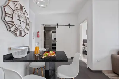 a dining room with a table and a clock on the wall at Apartamento Costa in Funchal