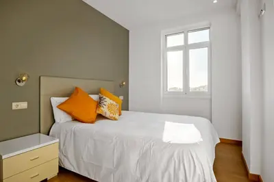 a bedroom with a bed with orange pillows and a window at Apartamento Eden in Funchal