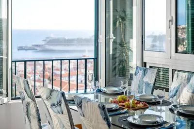 a dining room with a table with a view of the ocean at Apartamento Eden in Funchal