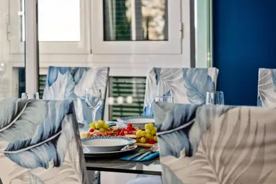 a dining table with a plate of fruit and wine glasses at Apartamento Eden in Funchal
