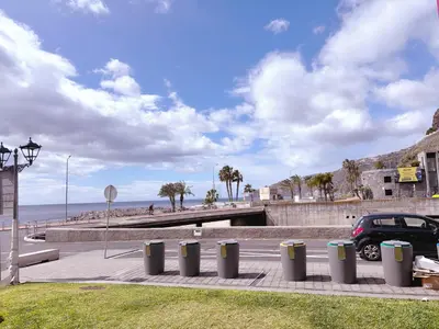 a row of trash cans on a sidewalk near the beach at ALc in Ribeira Brava