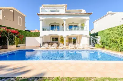 a villa with a swimming pool and a house at The White House in Lagos